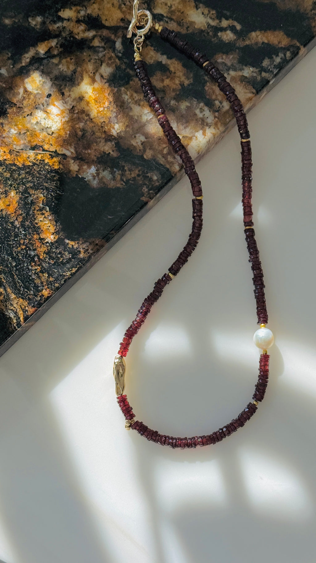 Quiet Flame · Minimalist necklace featuring natural garnet beads