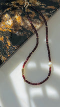 Quiet Flame · Minimalist necklace featuring natural garnet beads